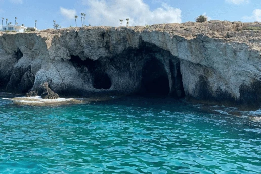 Sea caves carved into the cliffs above clear turquoise water near Ayia Napa, Cyprus