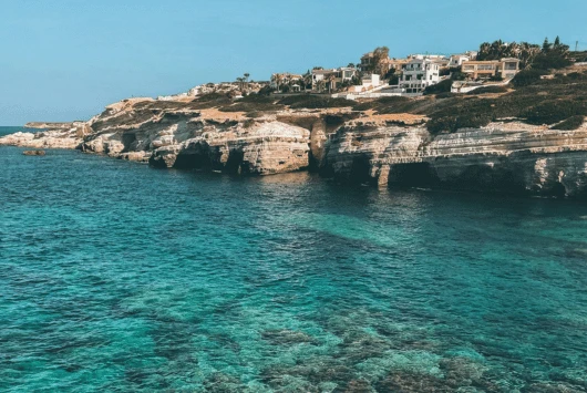 Clear turquoise water below the rocky Cape Greco coastline near Ayia Napa