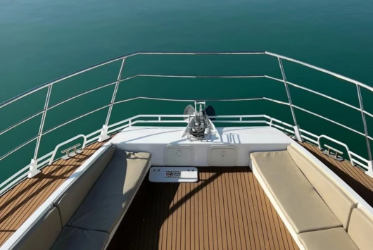 Yacht-style sofa seating at the front of the SCUBACAT catamaran with a teak deck