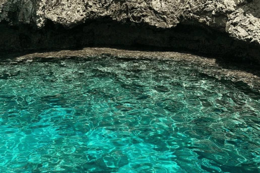 Limestone cliffs and sea caves rising above the turquoise water along the Cape Greco coastline near Ayia Napa