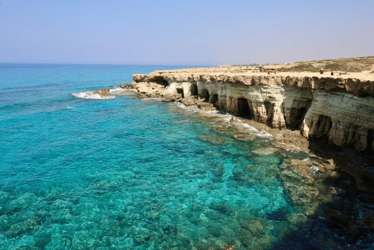 Limestone sea caves and clear turquoise water along the Cape Greco coast near Ayia Napa