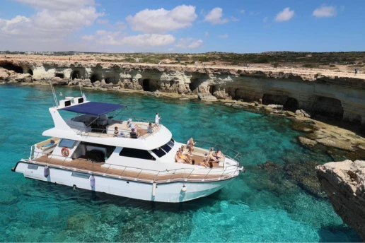 SCUBACAT catamaran on clear turquoise water beside the Sea Caves cliffs near Ayia Napa