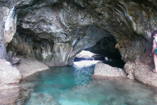 Inside the Ayia Napa Sea Caves, with a natural rock arch over a clear turquoise pool